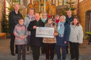 Die Vorsitzende der Frauengemeinschaft, Margret Rottauscher (vorne, 3.v. links) überreicht Pfarrer Michael Wilhelm (vorne, 2. von links) den Spendenscheck über 500 Euro. Mit ihr freuen sich das Team der Frauengemeinschaft und die Vertreter des Fördervereins der Kirche St. Hubertus.